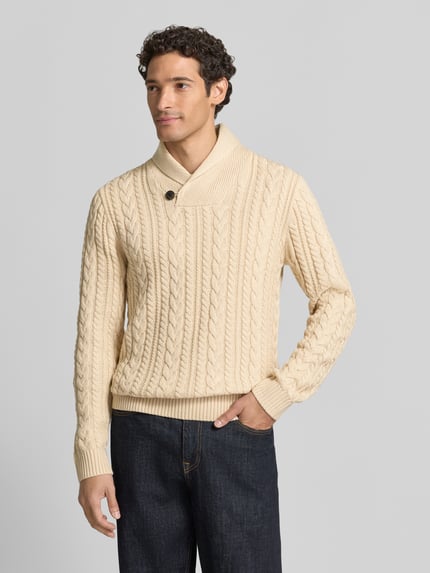Männermodel trägt Strickpullover mit Zopfmuster Modell 'CALLUM' von JACK & JONES Premium in Beige, Material-Mix, Schalkragen, Knopfverschluss, krój slim fit, Ganzkörperansicht von vorne.