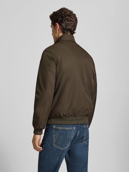 Männermodel trägt Blouson mit Zweiwege-Reißverschluss und Eingrifftaschen von Geox in Dunkelgrün, Ganzkörperansicht Rückansicht. Herren Blouson, Regular Fit, Stehkragen, Rückenlänge 67 cm, Schulterbreite 46 cm, Brustweite 53 cm, Ärmellänge 68 cm.