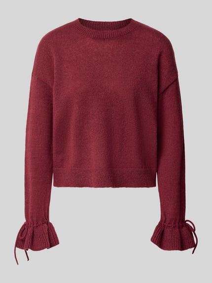 Produktfoto, Pullover mit Rüschenärmeln von PIECES w kolorze bordowym, gładki, dzianinowa struktura, okrągły dekolt, długie rękawy z falbanką, wykończenie ściągaczem, aplikacje: kokardka, falbany, dzianinowa obróbka materiału
