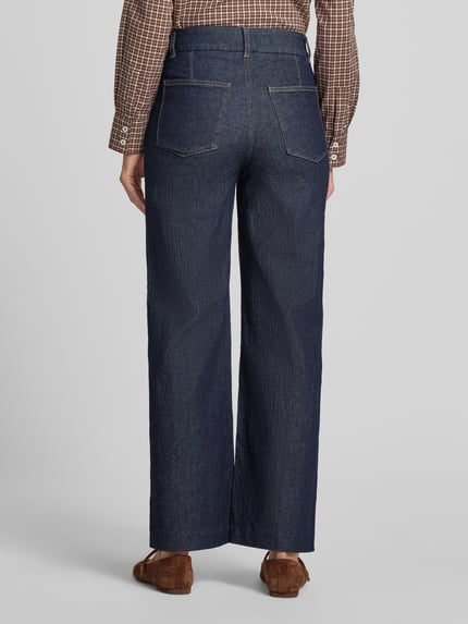 Frauenmodel trägt Wide Leg Jeans mit Ziernähten Modell 'PALOMA' von MANGO, dunkelblaue Denim-Struktur, sichtbare Gesäßtaschen, Ganzkörperansicht Rückansicht. Damenjeans, Wide Fit, Haken- und Reißverschluss, seitliche Eingrifftaschen, Bundweite 37 cm, Innenbeinlänge 75 cm, moderne Schnittführung.