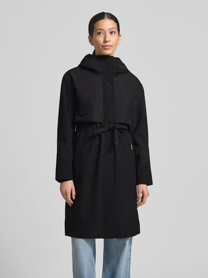 Frauenmodel trägt Mantel mit Kapuze und Tunnelzug Modell 'ELSA' von khujo, Regular-Fit, schwarze Farbe, Ganzkörperansicht von vorne, Rückenlänge bei Größe S: 96 cm, Schulterbreite: 49 cm, Brustweite: 51 cm, Ärmellänge: 60 cm.