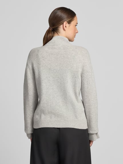 Frauenmodel trägt Strickpullover mit Stehkragen von Christian Berg Woman in Hellgrau, lockere Passform, gerippte Abschlüsse, Rückenansicht, Ganzkörperansicht Rückansicht.