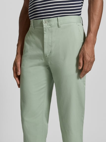 Männermodel trägt Slim Fit Chino aus Baumwoll-Mix von Tommy Hilfiger, Optik: Unifarben, Logo-Patch, Nahaufnahme Oberkörper.