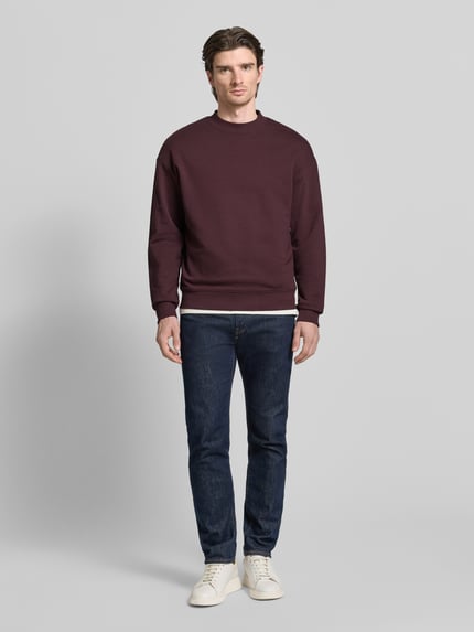Männermodel trägt Regular Fit Sweatshirt aus reiner Baumwolle Modell 'DAPOCREW' von HUGO, Optik: Unifarben, Label-Print, Ganzkörperansicht von vorne.