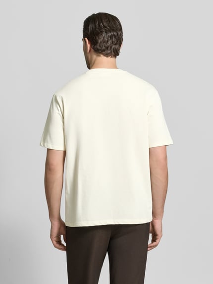 Männermodel trägt Oversized T-Shirt mit Rundhalsausschnitt von Lindbergh in Creme, reine Baumwolle, glatte Textur, Ganzkörperansicht Rückansicht.