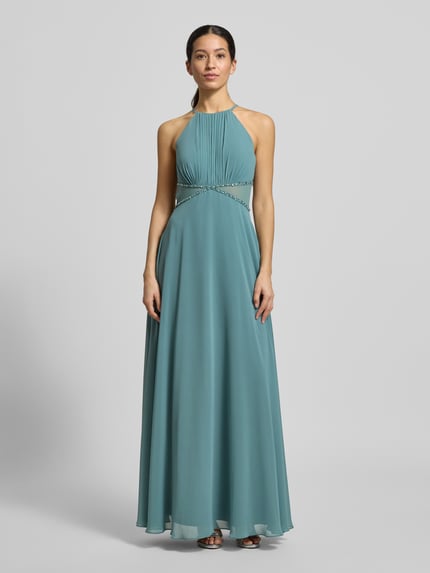 Kobiece modelka nosi Regular Fit Sukienka wieczorowa z obszyciem ozdobnymi kamieniami od Jake*s Cocktail, półprzezroczyste partie, taliowany krój, wiązanie na szyi, plisy, halka, długość tyłu 156 cm, szerokość klatki piersiowej 38 cm, kolor morski, gładka tkanina, widok całej sylwetki z przodu.