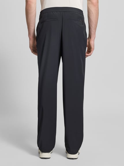 Männermodel trägt Hose mit elastischem Bund und Gesäßtaschen von ARMANI EXCHANGE, Relaxed-Fit, Material-Mix, Ganzkörperansicht Rückansicht.