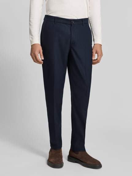Männermodel trägt Regular Fit Anzughose mit Bügelfalten von Les Deux, dunkles Blau, Material-Mix mit Woll-Anteil, Nahaufnahme Unterkörper.