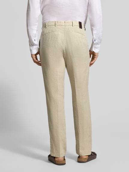 Męski model nosi Straight Fit Leinenhose aus reinen Leinen Modell 'Lynx' od MMX w kolorze beżowym, tylny widok całej sylwetki. Prosta nogawka, kieszenie z tyłu, szerokość w rozmiarze 32/32: 43 cm, długość nogawki od wewnątrz 81 cm.