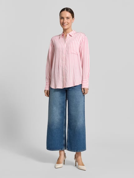 Frauenmodel trägt Relaxed Fit Bluse aus Viskose-Mix von Comma mit Hemdblusenkragen und Knopfleiste, rosa-weiß gestreift, Damen Bluse, Rückenlänge 76 cm, Ärmellänge 57 cm, Ganzkörperansicht von vorne.