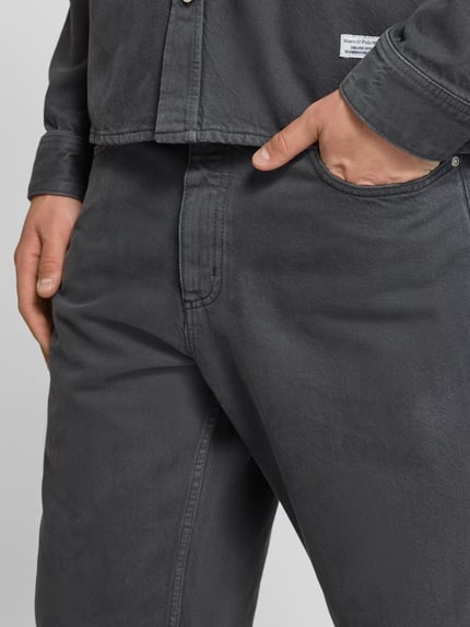 Männermodel trägt Wide Fit Jeans aus reiner Baumwolle Modell 'STEN' von Marc O'Polo Denim in Dunkelgrau, Nahaufnahme Hüftbereich.
