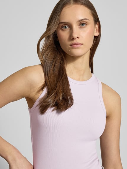 Vrouwenmodel draagt Tanktop in Ripp-Optik van REVIEW in lichtroze, katoen-elastaanmix, nauwsluitende fit, ronde hals, detailopname bovenlichaam.