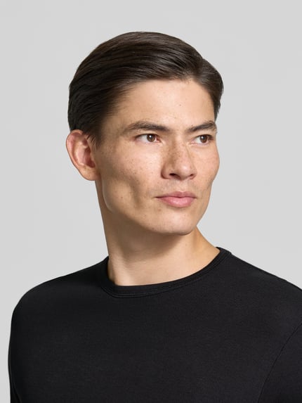 Männermodel trägt Regular Fit Longsleeve aus reiner Baumwolle Modell 'Basic' von Lindbergh, schwarze Farbe, Nahaufnahme Oberkörper.