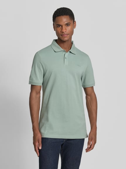 Męski model nosi Regular Fit Poloshirt aus reiner Baumwolle von s.Oliver RED LABEL, bawełniany pikowany materiał, krótki rękaw, jednolita zieleń, widok z przodu, całe ciało.