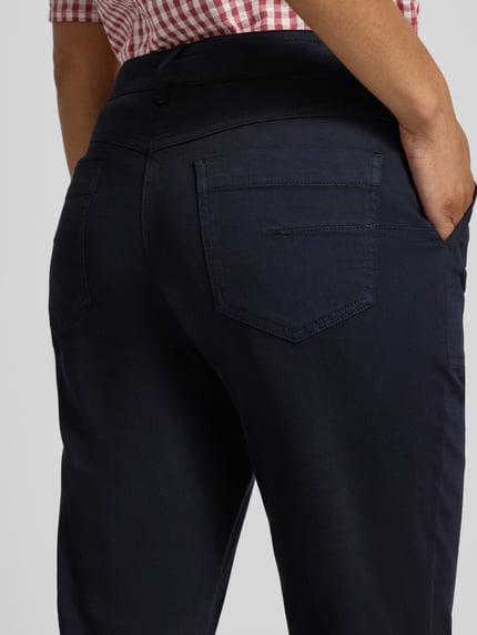 Frauenmodel trägt Chino mit Fransensaum von Marc Cain in Dunkelblau, Baumwoll-Mix mit Stretch-Anteil, Detailaufnahme Rückansicht.