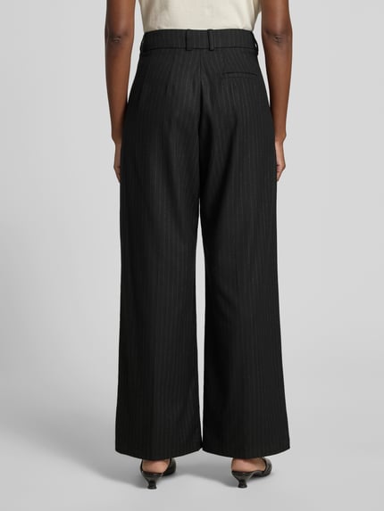 Frauenmodel trägt Wide Fit Hose mit Viskose-Anteil von black palms in Schwarz mit Bundfalten, Gesäßtasche, Elastischer-Material-Mix, Ganzkörperansicht Rückansicht.