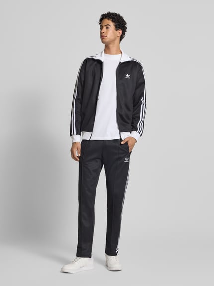 Mannelijk model draagt Trainingshose mit Label-Stitching Modell 'BECKENBAUER' van adidas Originals, zwart, regular fit, katoenmix, elastische tailleband, achterzak, context heren, geheellichaamsaanzicht van voren.