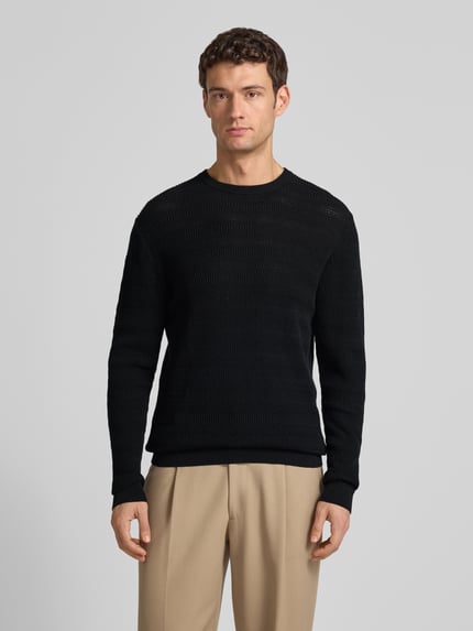 Männermodel trägt Regular Fit Strickpullover mit Rundhalsausschnitt von Antony Morato aus reiner Baumwolle, Strukturmuster, Ganzkörperansicht von vorne.