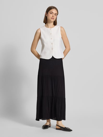 Vrouwenmodel draagt uitlopende dames maxirok in effen kleuren met volants en kreuklook, materiaal zuiver viscose, Ausgestellter Maxi-Rock aus reiner Viskose Modell 'MIKKA' van Only, Ganzlichaamsaanzicht van voren.