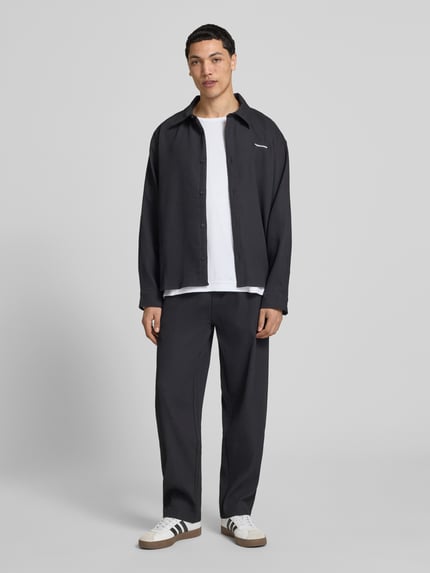 Männermodel trägt Sweatpants mit Strukturmuster und elastischem Bund von Pegador in Schwarz, Material-Mix mit Stretch-Anteil, Relaxed-Fit, Ganzkörperansicht von vorne