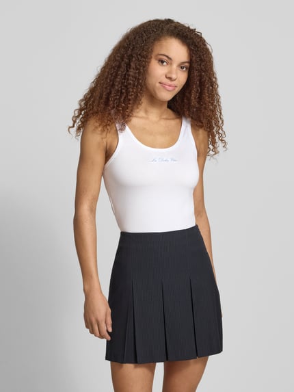 Vrouwenmodel draagt wit tanktop met ronde hals en borduursel, slim fit van mix van katoen en elastaan, ruglengte maat S 36 cm, Tanktop met Rundhalsausschnitt und Stickerei van REVIEW, volledige lichaamsopname van voren.