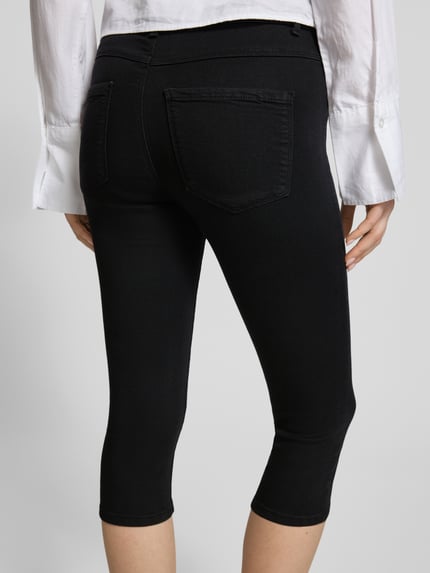 Frauenmodel trägt Regular Fit Caprijeans aus Viskose-Mix Modell 'RAIN' von Only in Schwarz mit 5-Pocket-Design, Ganzkörperansicht Rückansicht.