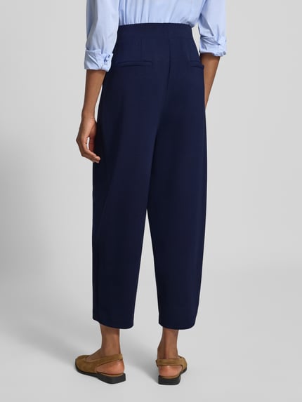Frauenmodel trägt Barrel Fit Sweatpants aus Modal-Mix von Rich & Royal in Dunkelblau mit elastischem Bund und gelegten Falten, Ganzkörperansicht Rückansicht.