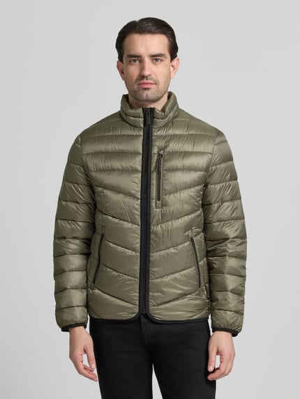 Männermodel trägt Regular Fit Steppjacke mit Stehkragen von Tom Tailor in Olivgrün, unifarben, mit Reißverschluss und Kontraststreifen, Ganzkörperansicht von vorne.