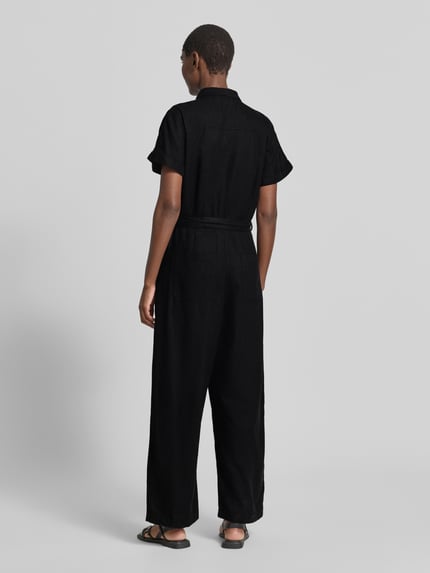 Vrouwenmodel draagt zwarte dames jumpsuit uit linnenmix met viscose, getailleerd model, model 'LINNO' van ICHI, achteraanzicht volledige lengte.
