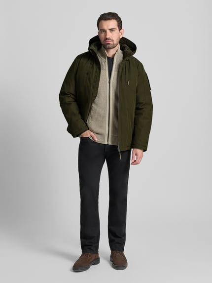 Männermodel trägt Parka met kapuze van PME Legend in olijfgroen, regular fit, met rits en zakken, voorkant volledig zichtbaar, Ganzkörperansicht von vorne.