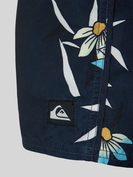 Produktfoto, Badeshorts im Allover-Look von Quiksilver mit Blumenmuster in Blau, Weiß und Gelb, sichtbare Naht, Detailaufnahme