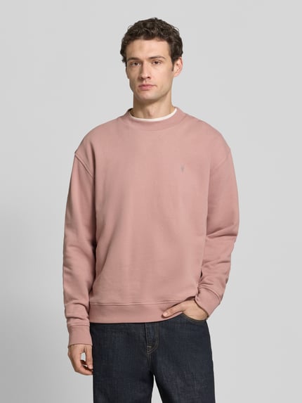 Männermodel trägt Sweatshirt mit Logo-Stitching Modell 'asher crew' von AllSaints, unifarben, langarm, Rippstrick, Ganzkörperansicht von vorne.