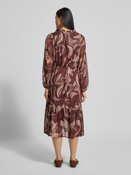 Modelka kobieca nosi Midikleid mit V-Ausschnitt Modell 'Za44raa' od ZABAIONE, brązowa sukienka w stonowane wzory, lekka tekstura, długość do łydek, długie rękawy, A-linia, perspektywa całej sylwetki z tyłu.