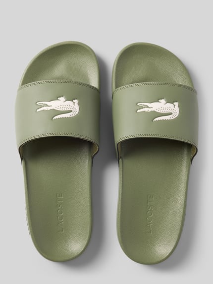 Produktfoto, zielone Badeschuhe mit Logo-Print Modell 'SERVE SLIDE 0.0' von Lacoste, płaska podeszwa strukturalna, nosek zaokrąglony, fason wsuwany