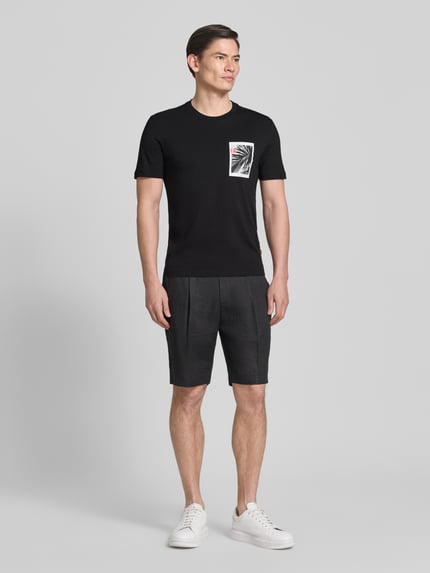 Męski model nosi Regular Fit T-Shirt aus reiner Baumwolle Modell 'TE_BOARD' von BOSS Orange, czarny, gładki, nadruk foto, tkanina jersey, krótki rękaw, przód, widok całej sylwetki