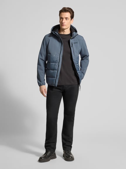 Männermodel trägt Regular Fit Steppjacke mit wasserabweisender Funktion von Tom Tailor Denim, unifarben, Kapuze, Ganzkörperansicht von vorne.