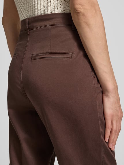 Vrouwenmodel draagt Chino aus Lyocell-Mix mit Eingrifftaschen van Jake*s Casual in bruin, gladde textuur, regular fit, steekzakken, achterzakken, mix van lyocell en katoen, binnenbeenlengte maat 36: 74 cm, bandwijdte maat 36: 38 cm, detailopname heup en achterzijde.