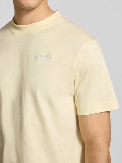 Männermodel trägt T-Shirt mit Label-Stitching Modell 'ACCIANO CLASSIC' von Ellesse aus reiner Baumwolle, Nahaufnahme Oberkörper.