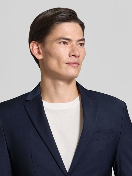 Männermodel trägt 2-Knopf-Sakko in unifarbenem Design von CK Calvin Klein, Mieszanka bawełny z dodatkiem streczu, krój regular fit, kieszenie z patką, jednokolorowy, Nahaufnahme Oberkörper.