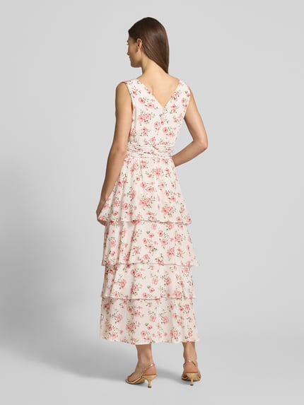 Modelka nosi Cocktailkleid aus Viskose im Stufen-Look von Guido Maria Kretschmer, różowe kwiaty, wiązanie w talii, długość midi, widok całej sylwetki z tyłu.
