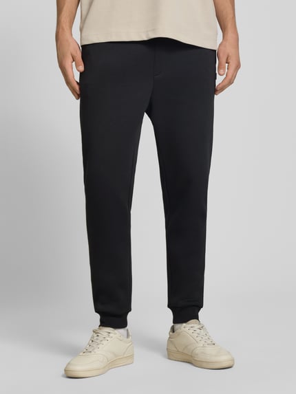 Mannenmodel draagt zwarte Regular Fit sweatpants met steekzakken Model 'GORDON' van JACK & JONES, Materiaalmix met katoen, elastische band met tunnelkoord, gulp, steekzakken, achterzak, binnenbeenlengte bij maat M 70 cm, Ganzkörperansicht van voren.