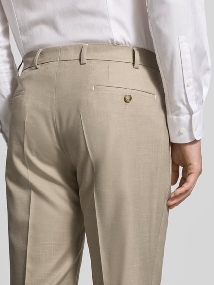 Männermodel trägt Moden Fit Anzughose mit Bügelfalten Modell 'Sergio' von DIGEL in Beige, Material-Mix mit Viskose-Anteil, Gesäßtaschen, Detailaufnahme Rückansicht.