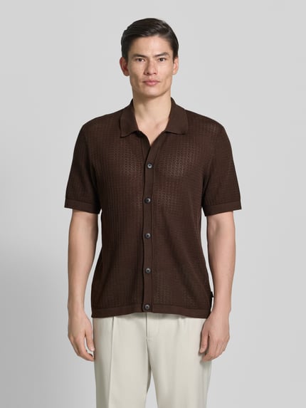 Männermodel trägt Regular Fit Freizeithemd in Strick-Optik Modell 'Owen' von Jack & Jones Premium, braun, Semitransparent, Kurzärmelig, Kentkragen, durchgehende Knopfleiste, Reine Baumwolle; Rückenlänge 72 cm, Schulterbreite 47 cm, Ärmellänge 27 cm, Ganzkörperansicht von vorne.