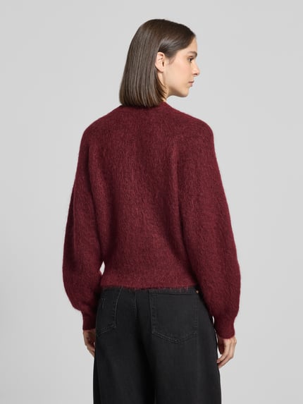 Frauenmodel trägt Pullover aus Mohair mit geripptem Abschluss von Selected in unifarbenem Weinrot, Stricktextur, Ganzkörperansicht Rückansicht.
