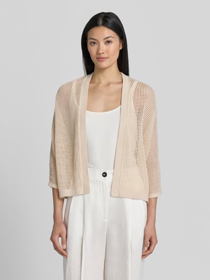 Vrouwenmodel draagt Strickjacke in open pasvorm met 3/4-mouw van comma, puur katoen, structuurpatroon, ruglengte maat S 54 cm, mouwlengte 58 cm, kleur lichtbeige, fijn gebreide textuur, geheel witte outfit, geheel witte achtergrond, frontale volledige lichaamsopname.