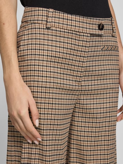 Frauenmodel trägt Wide Fit Stoffhose aus Woll-Baumwoll-Mix mit Karomuster von Lanius, Gürtelschlaufen, Bundfalten, Gesäßtasche, Nahaufnahme Oberkörper.