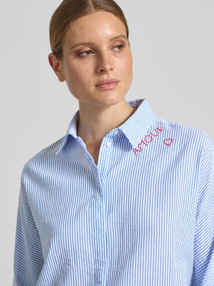 Vrouwenmodel draagt Relaxed Fit Bluse mit Stitchings und 3/4-Arm van Oui, fijn blauw-wit gestreept puur katoen, overhemdkraag, Nahaufnahme bovenlichaam.