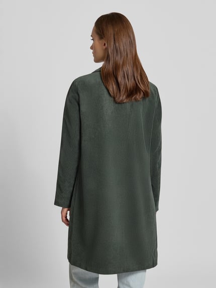 Frauenmodel trägt Regular Fit Mantel mit Reverskragen Modell 'ASTRID' von ONLY aus unifarbenem Cord, Ganzkörperansicht Rückansicht.