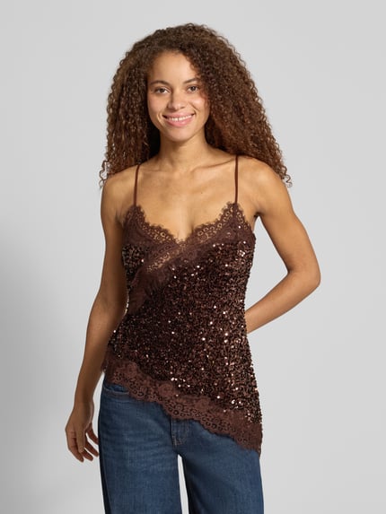 Frauenmodel trägt Regular Fit Blusentop mit Paillettenbesatz Modell 'PCKAMMY' von PIECES in Braun mit Spitzenstruktur und asymmetrischem Saum, Nahaufnahme Oberkörper.