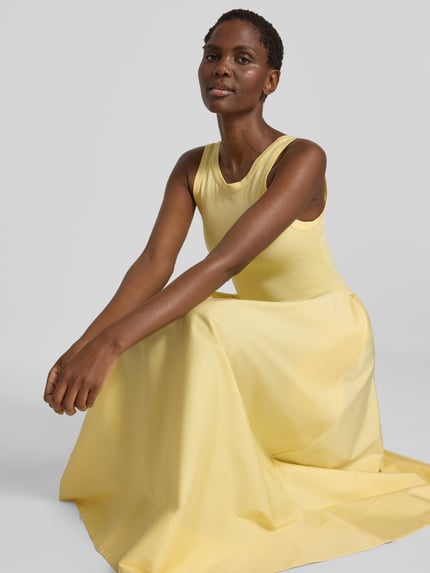 Frauenmodel trägt Fit and Flare Freizeitkleid aus Viskose-Mix von Polo Ralph Lauren in hellem Gelb mit glatter Textur, Nahaufnahme Oberkörper.